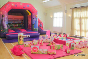 bright pink bouncy castle with matching soft play and themed ball pool.