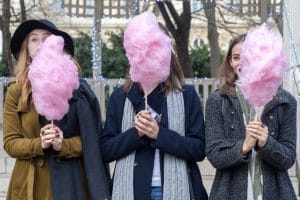 three girls eat candy