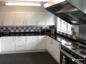 Kitchen oven and microwave white cupboards and worktops.